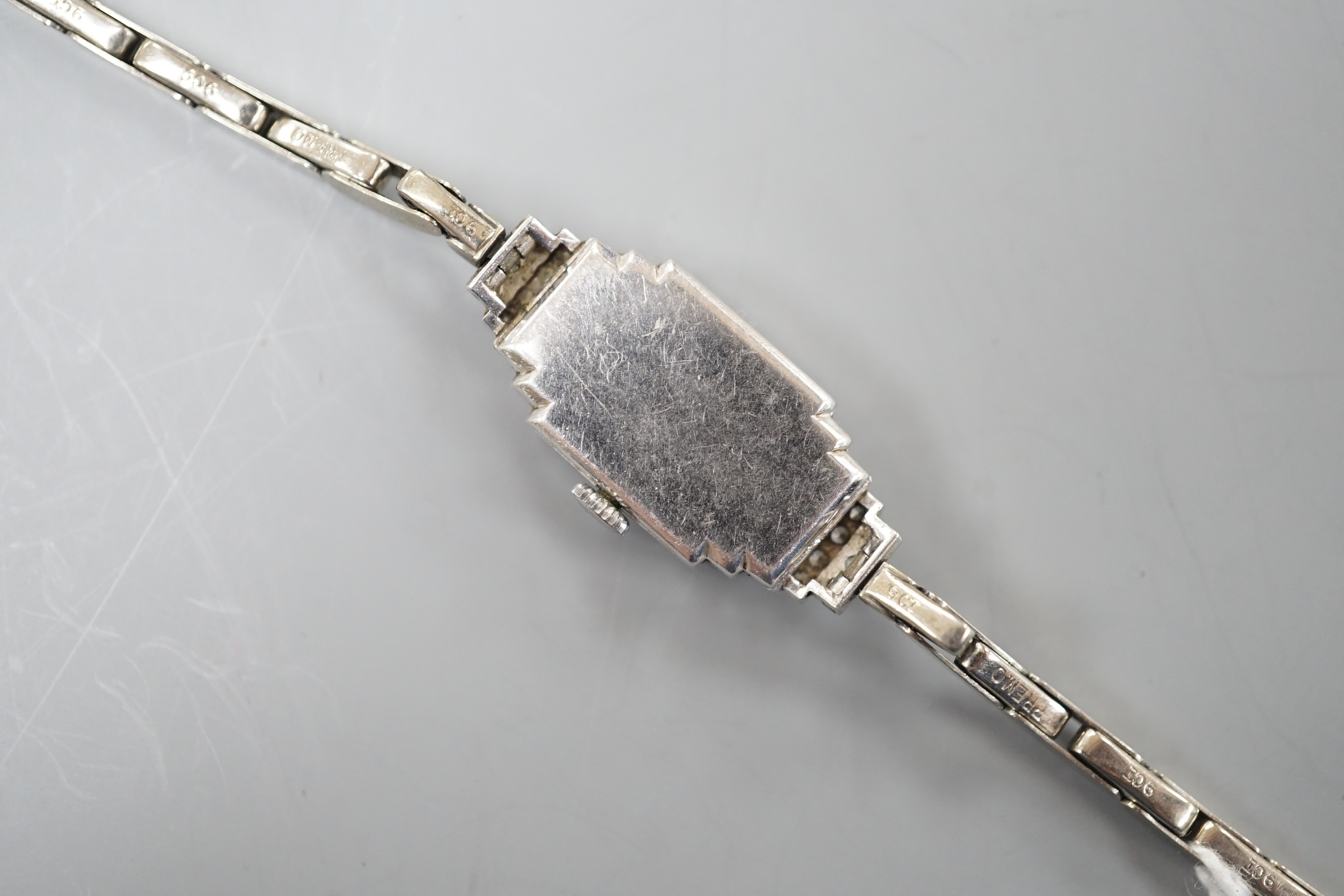 A lady's mid 20th century white metal (stamped platinum) and diamond cluster set Vertex cocktail watch, with stepped lugs, on a 9ct white metal expanding bracelet, 15.5cm, gross weight 15.6 grams.